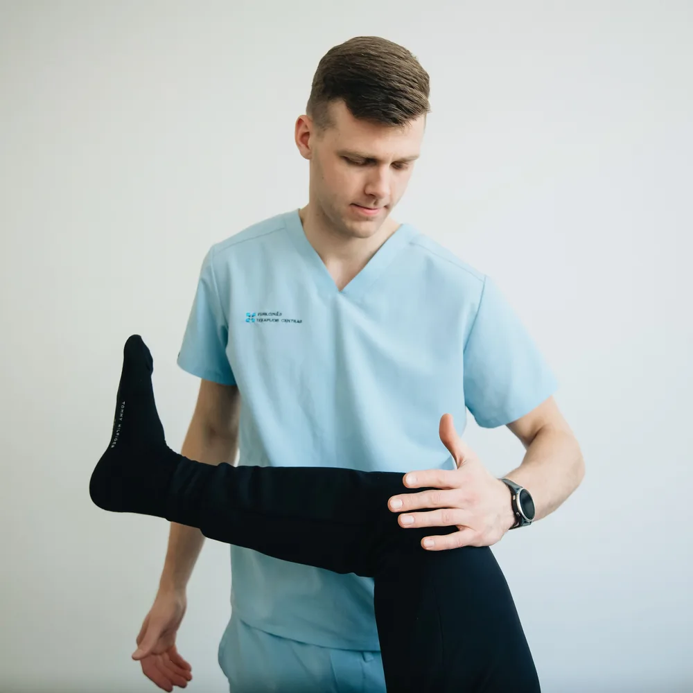 Physiotherapist assessing a patient’s knee in a clinical setting